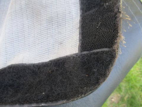 1996 Ford Bronco - Detail of a vehicle's soft top edge, showing black velcro and white mesh material.