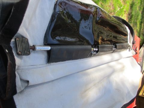 1996 Ford Bronco - Close-up view of a soft top's latch mechanism, a metal rod and rubber seal.