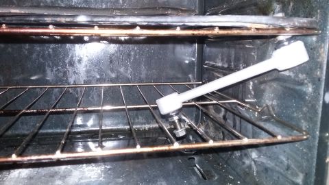2000 Pontiac Grand Prix - A socket wrench is shown attached to a bolt on an oven rack inside a dirty oven.