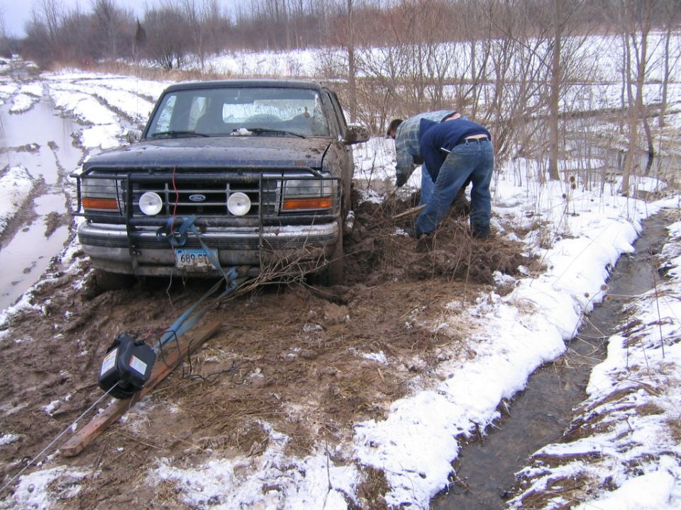 winch hooked to tow strap hooked to brush guard to frame