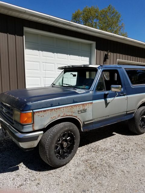1987 Ford Bronco - This 1987 Ford Bronco shows significant wear and tear, including rust on its two-tone paint job.