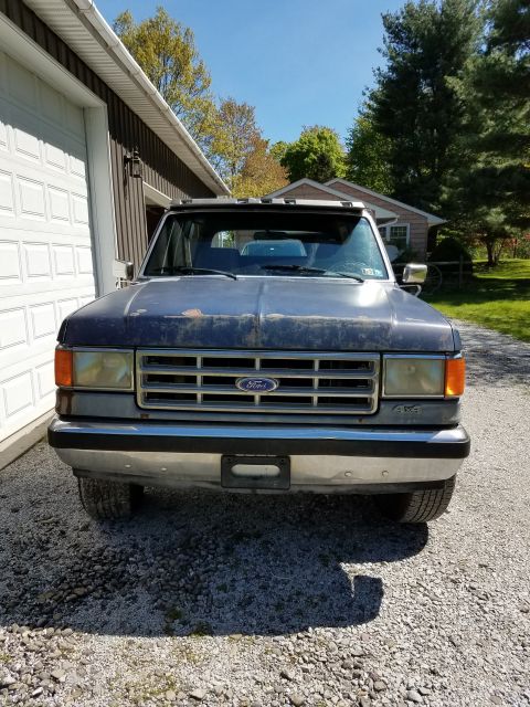 1987 Ford Bronco - Front view of a dark blue 1987 Ford Bronco parked in a driveway.