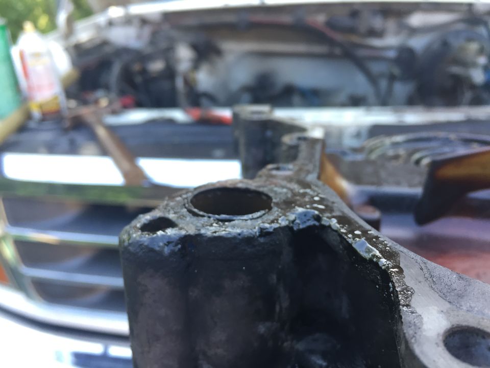 close-up of greasy engine bracket with engine bay in background