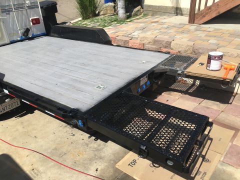 1992 Jeep Wrangler - A flatbed trailer with deployable ramps is shown, with a paint can and tools nearby.