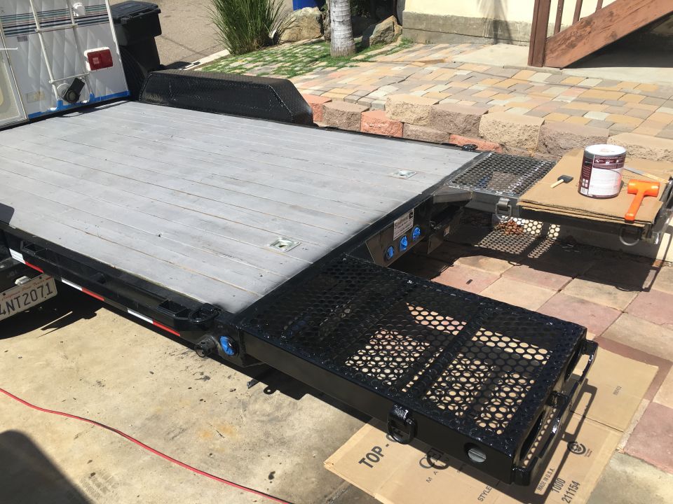 Flatbed trailer with ramps and a paint can