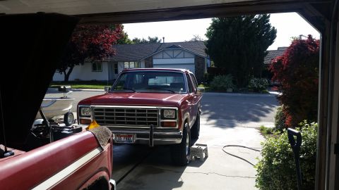 1985 Ford Bronco - Red 1985 Ford Bronco in garage with another vehicle's hood up. License plate is visible.