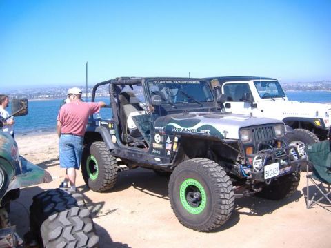 1992 Jeep Wrangler - Two Jeep Wranglers are parked on a sandy beach with the ocean in the background.