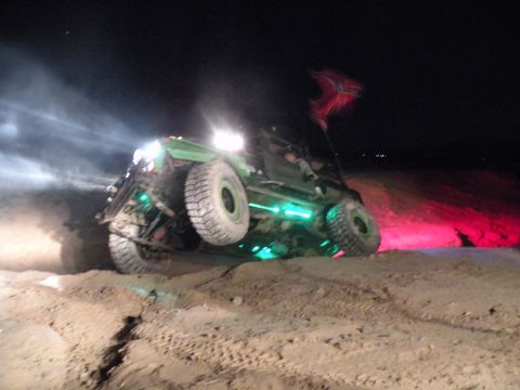 1992 Jeep Wrangler - This modified off-road vehicle is shown at night with colorful underglow lighting illuminating the terrain.