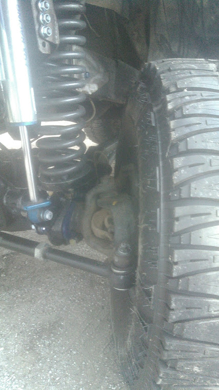 1978 Ford Bronco - Suspension and tire detail of an unknown vehicle.