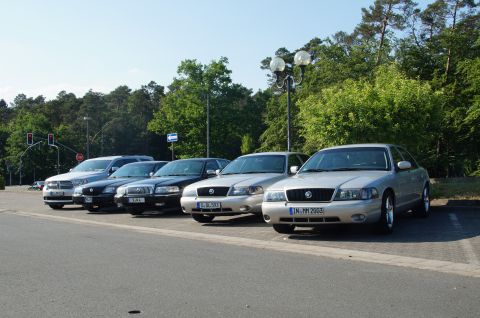 2003 Mercury Marauder - A row of cars, including a silver 2003 Mercury Marauder, are parked in a lot on a sunny day.