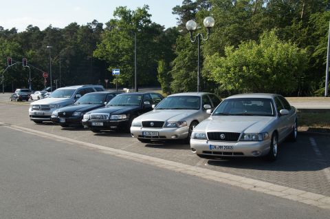 2003 Mercury Marauder - A line of sedans and an SUV are parked in a lot on a sunny day.