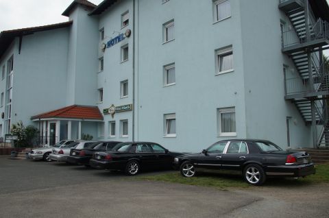 2003 Mercury Marauder - Several sedans are parked in front of a hotel, with one black 2003 Mercury Marauder prominently displayed.