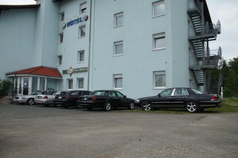 2003 Mercury Marauder - A black 2003 Mercury Marauder is parked in a lot outside a hotel, alongside several other vehicles.