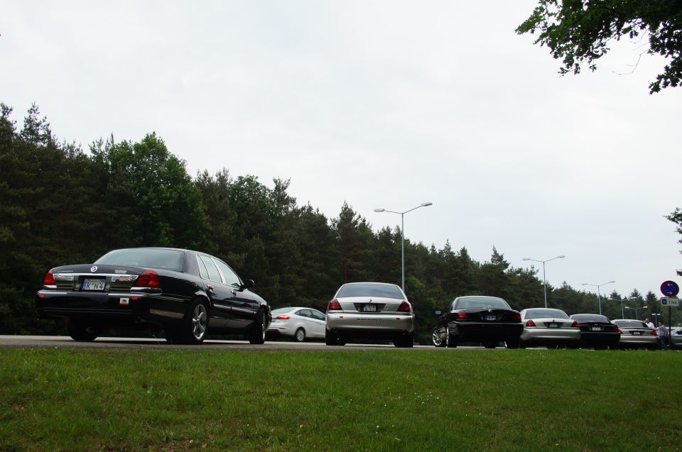 Black 2003 Mercury Marauder from rear, parked on grass next to a road with other cars