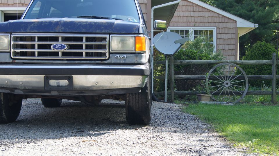 Front view of a dark blue Ford truck with a chrome grille and bumper.