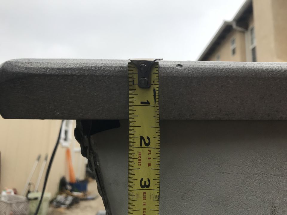 Measuring tape against a grey boat railing