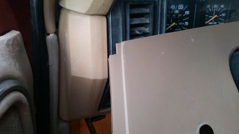 1985 Ford Bronco - The interior of a vehicle shows a close-up of the dashboard gauges and a tan plastic trim piece partially obscuring the view. The gauges in…