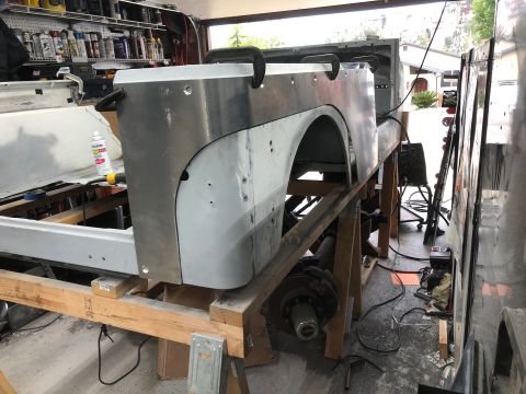 1992 Jeep Wrangler - A partially modified Jeep Wrangler body is shown supported by wooden sawhorses in a garage. New metal body panels, including a fender flare…