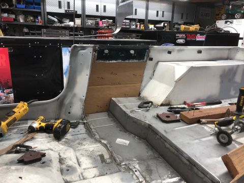 1992 Jeep Wrangler - The interior of a vehicle undergoing restoration, showing bare metal floors, custom metalwork on the rear seating area, and various tools s…