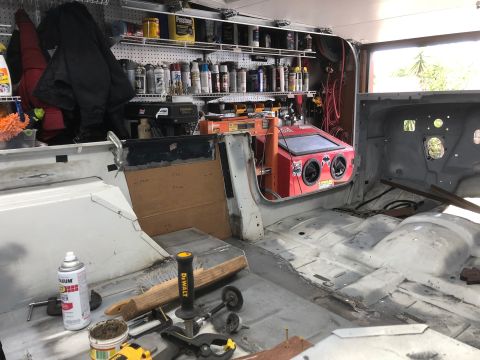 1992 Jeep Wrangler - The interior of a white Jeep Wrangler is shown undergoing restoration in a garage. Tools and automotive parts are scattered around the vehi…