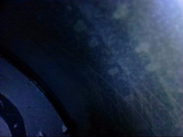 Interior of a wheel well, showing dark textured surface with scuff marks.