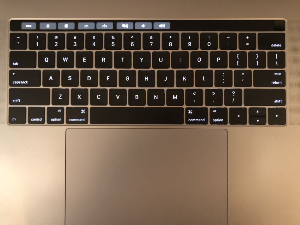 Laptop keyboard and trackpad with illuminated keys.