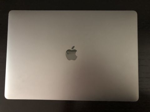 1989 Ford Bronco - The image shows the closed lid of a silver laptop with a prominent Apple logo in the center. The laptop is placed on a dark, textured surfa…