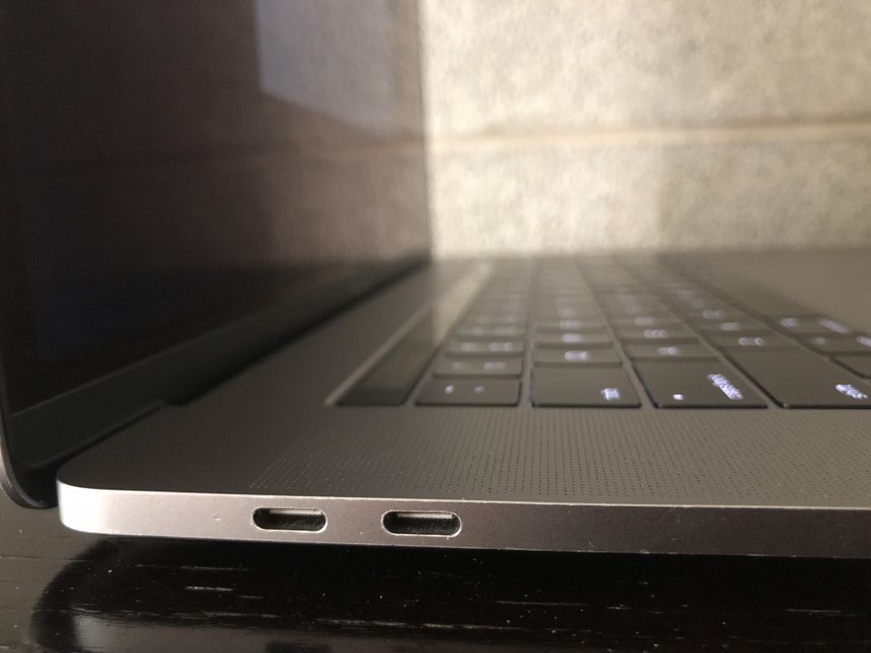 Close-up of a silver laptop's side with USB-C ports and keyboard.