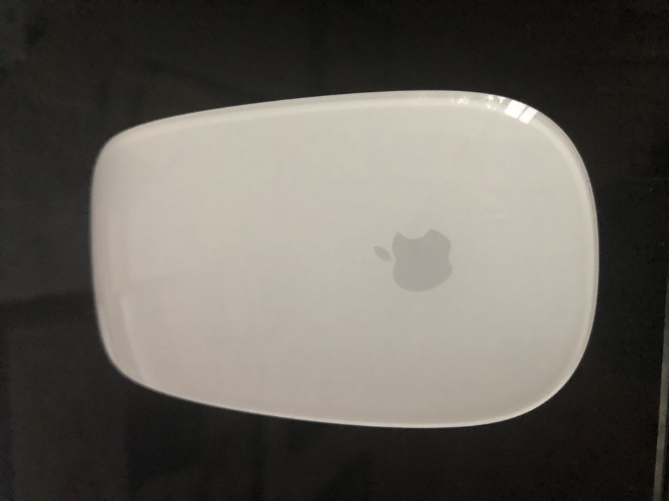 White Apple Magic Mouse on a dark surface