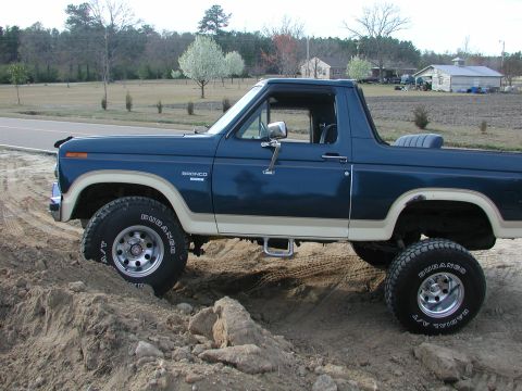 1985 Ford Bronco - This 1985 Ford Bronco is shown off-road with a lifted suspension and aggressive tires.