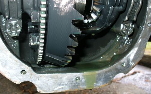 1992 Ford Bronco - Close-up view of the differential gears and housing of a 1992 Ford Bronco, showing the ring gear and pinion gears coated in green fluid.