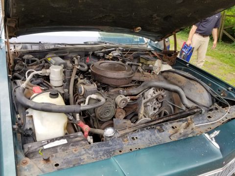 2001 Ford Crown Victoria - Photograph of an engine compartment with coolant reservoir, not a technical document.