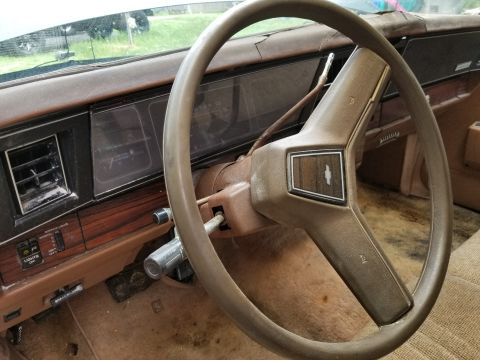 2001 Ford Crown Victoria - The interior of an older car shows a brown dashboard, steering wheel, and worn seats.