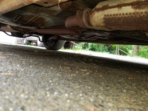 2001 Ford Crown Victoria - The underside of a vehicle is shown, with visible rust and exhaust components.