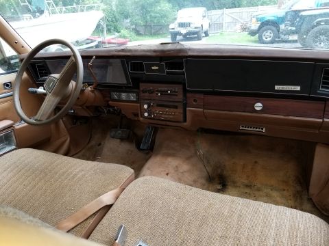 2001 Ford Crown Victoria - Interior view of a vintage car, brown upholstery and wood-grain accents on the dashboard.