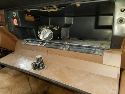 2001 Ford Crown Victoria - The interior of a vehicle shows an open glove box with dust and some mechanical components visible.