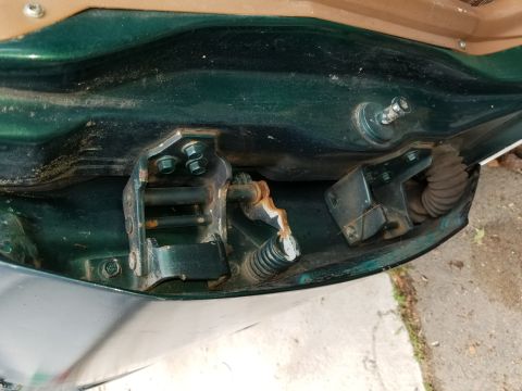 2001 Ford Crown Victoria - Close-up of a car's door hinge mechanism, revealing signs of wear and rust.