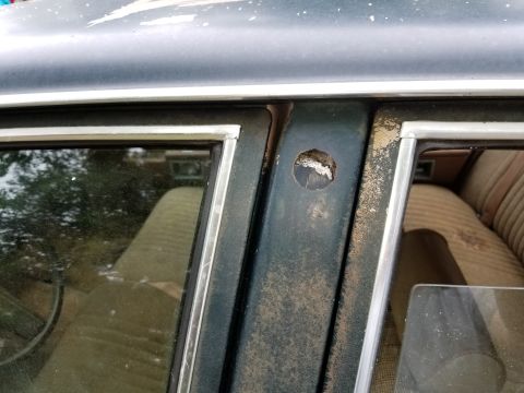 2001 Ford Crown Victoria - Damage to the B-pillar of a car, with interior upholstery visible.