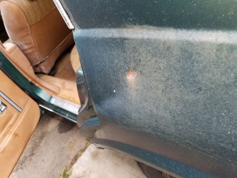 2001 Ford Crown Victoria - Close-up view of a car's exterior and interior, showing a small rust spot on the fender.