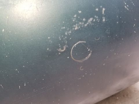 2001 Ford Crown Victoria - Close-up of a green car door showing damage and water residue.