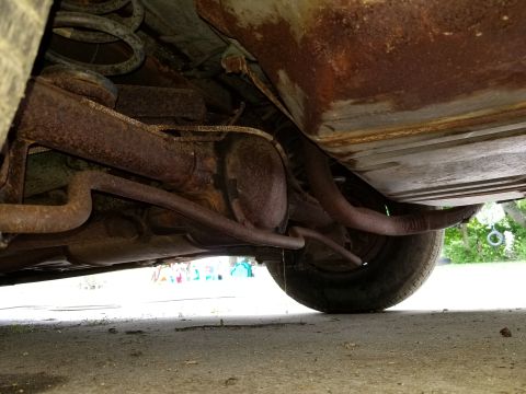 2001 Ford Crown Victoria - Heavily rusted undercarriage components including suspension and exhaust pipes are visible.