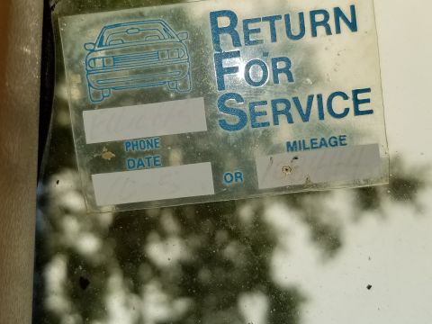 2001 Ford Crown Victoria - Dealer 'Return For Service' windshield reminder sticker with phone, date and mileage fields partly filled in.