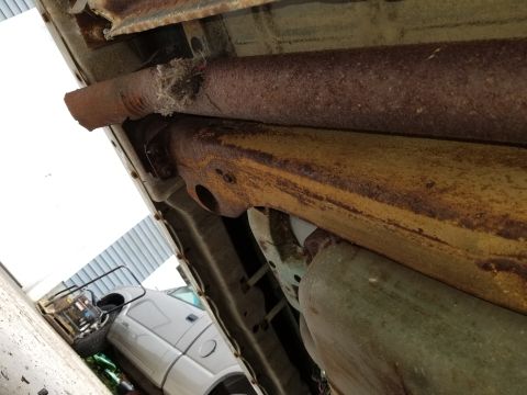 2001 Ford Crown Victoria - Underbody view of a vehicle's rusted exhaust system and frame components.