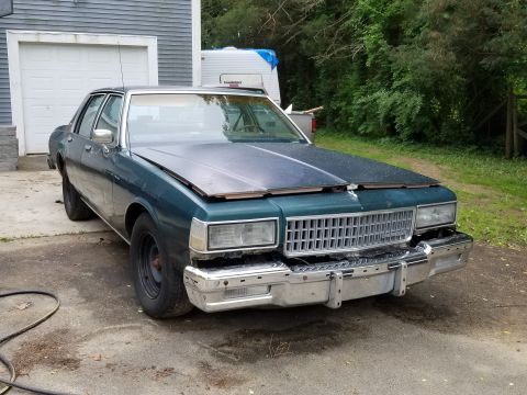 2001 Ford Crown Victoria - This 1989 Chevrolet Caprice is parked outside a garage with a trailer in the background.
