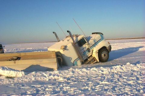 1979 Ford Bronco - A semi-truck is stuck in the snow, with its front end partially on a flatbed trailer.