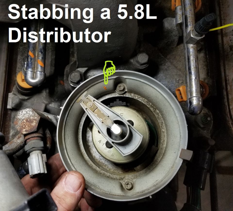 Distributor with rotor being installed into a V8 engine, hand holding it, alignment mark visible