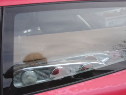 1973 Ford Ranchero - A red car's interior is visible, with a chrome taillight assembly circular lenses.