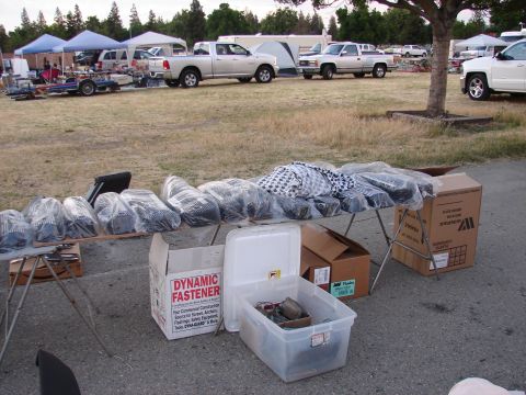 1973 Ford Ranchero - Various automotive parts are displayed for sale at an outdoor event, with several trucks visible in the background.
