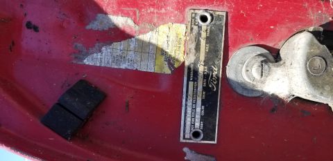 1966 Ford Ranchero - A Ford VIN plate, dated 1972, is visible on a red metal surface, alongside faded registration stickers.