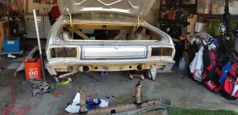 1974 Plymouth Duster - The rear of a 1974 Plymouth Duster is shown in a garage, stripped down for restoration work.
